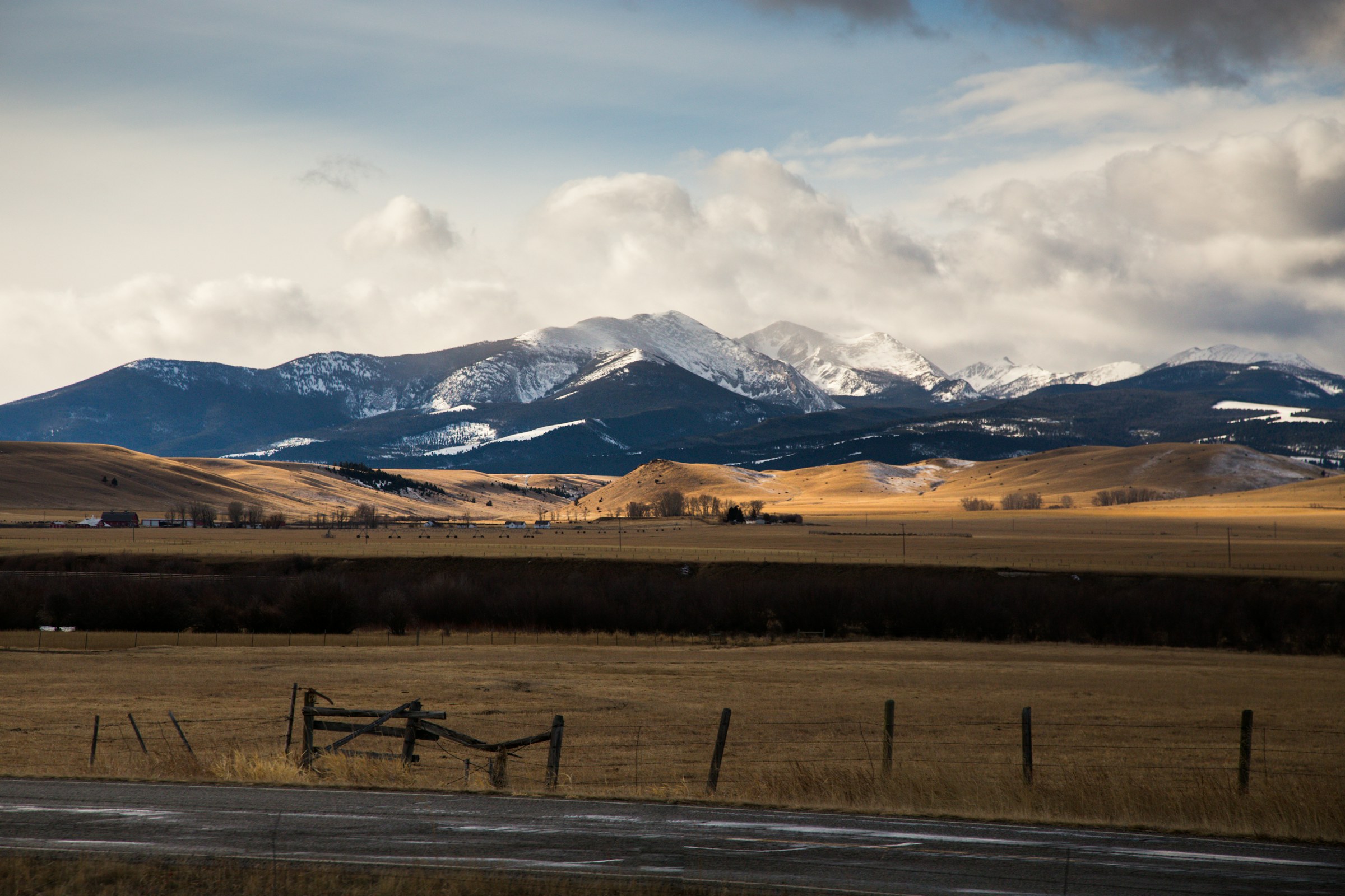 Open Montana grassland beneath snow-covered mountains